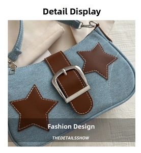 Detail of denim underarm bag with brown leather stars and silver metal buckle