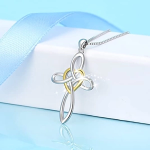 Elegant two-tone heart and cross pendant necklace on a jewelry box gift display