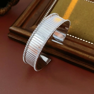 Gros plan du bracelet jonc plaqué or avec texture verticale et pavé de cristaux