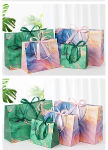 Detail of marble pattern gift bags with golden textures and elegant ribbon handles