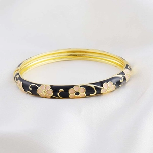 Detail of enamel bangle with pink flower motifs on a black and gold finish