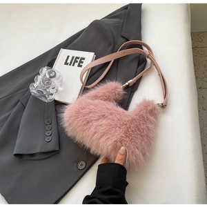 Detailed close-up of pink faux fur texture and adjustable leather strap on handbag