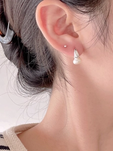 Close-up of 925 sterling silver pearl earring worn on ear with minimalist design