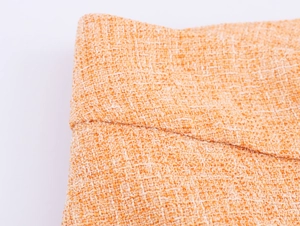Détail macro du tissage et de la texture du tissu en tweed orange et blanc