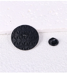 Detailed back view of enamel pin with rhombus texture and black rubber clutch
