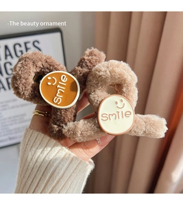 Detail of plush smile hair clips in brown and apricot with soft textured fur fabric