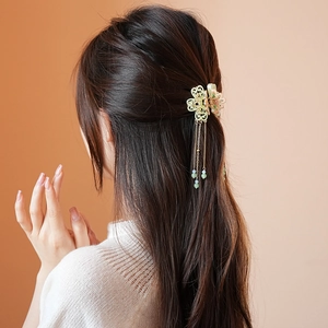 Detail of floral hair claw with pearl tassels on woman's updo hairstyle