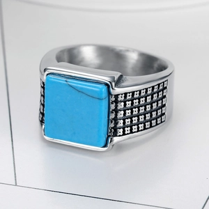 Macro detail of men's vintage steel ring with square blue turquoise and floral engravings