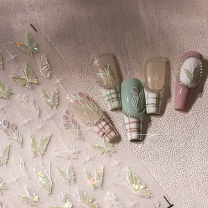 Detailed macro view of iridescent butterfly and tulip nail decals applied to press-on nails