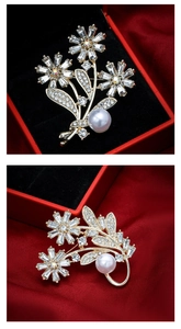 Close-up of a floral gold brooch with sparkling crystals and white pearl in a gift box