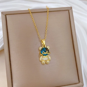Détail du pendentif ours doré avec sphère étoilée bleue et pierres de zircon