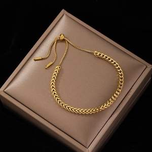 Golden woven wheat chain bracelet with adjustable bolo slide clasp on jewelry display