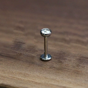 Macro shot of G23 titanium labret stud with a sparkling clear cubic zirconia heart inlay