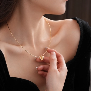 Dettaglio ravvicinato di una collana con ciondolo a fiore placcata in oro con zircone