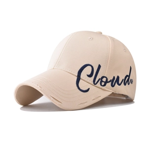 Close-up of beige cotton baseball cap with blue cloud embroidery and distressed brim detail