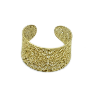 Detailed view of wide open bangle with intricate hollow flower patterns in gold finish