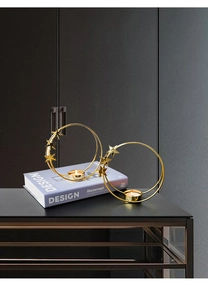 Detail of gold circle candle holder with star and snowflake accents on a modern cabinet