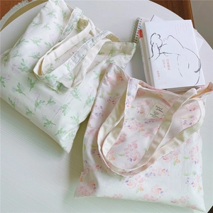 Detail of floral canvas tote bags with green leaf and pink flower patterns on cotton fabric