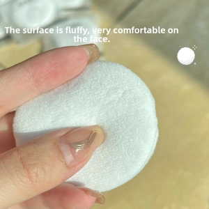 Close-up of white cotton velour powder puff showing dense soft fibers for makeup setting