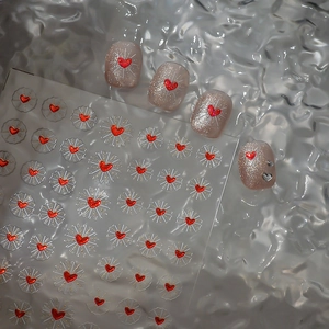 Golden sunburst red heart nail art stickers on iridescent shell background for manicure