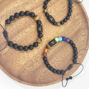 Vue détaillée des bracelets de yoga en obsidienne 8mm avec breloques lettres en métal