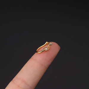 Macro shot of a gold-plated copper clip-on nose ring featuring sparkling cubic zirconia