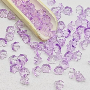 Macro view of purple translucent lily of the valley glass beads for DIY jewelry making