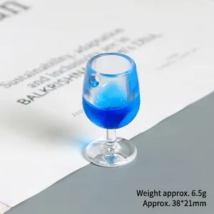 Close-up of a miniature blue resin wine glass charm with a pre-drilled hanging hole