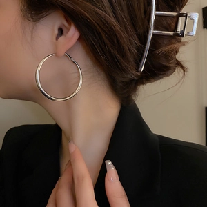 Minimalist silver geometric hoop earrings and matching hair clip shown on a fashion model