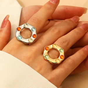 Close-up of vintage hollow hexagonal rings set with colorful gemstones in gold and silver