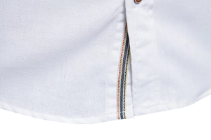 Close-up of white cotton shirt hem with decorative red yellow and blue striped ribbon