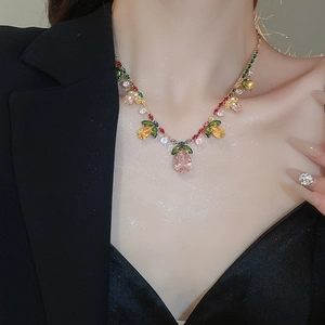 Model wearing a luxury floral zircon necklace with a pink teardrop pendant on black suit