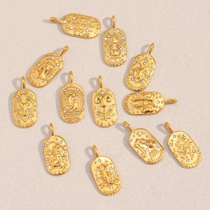 Flat lay of 18K gold-plated zodiac pendants featuring crystals and engraved constellation names