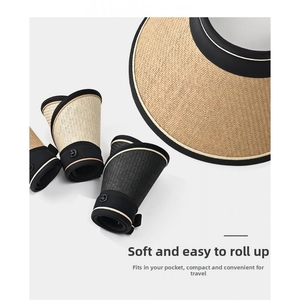 Detail of rollable straw sun hat showing portable design and side metal logo accent