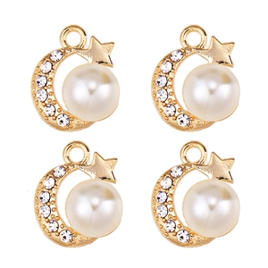 Close-up of gold star and moon pendants with pearls and rhinestones for DIY jewelry