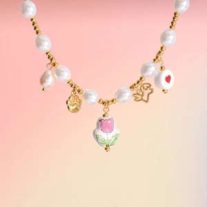 Detail of ceramic tulip and cat claw charms on a baroque pearl bracelet for women
