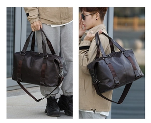 Detail of a large dark brown PU leather travel bag with handles and shoulder strap