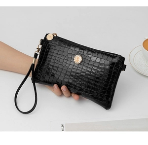 Detailed view of black croco pattern clutch bag with sparkling crystal hardware detail