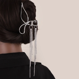 Silver bow hair claw with long rhinestone tassels worn by a model from a back view