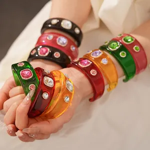 Vintage resin open bangles with colorful rhinestones on a minimalist background