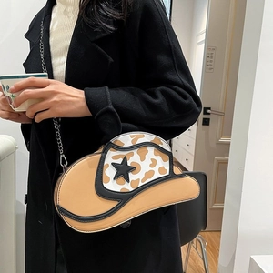 Unique cow print denim hat shaped chain shoulder bag with a black star accent