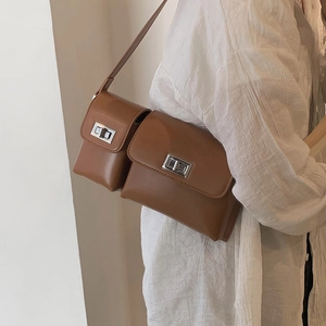 Close-up of brown baguette bag with dual pockets and silver rotating metal buckles