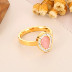 Detailed view of a gold ring featuring a pink teardrop stone with crystal accents