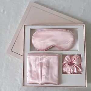 Pink satin sleep set including an eye mask, pillowcase, and scrunchie in a gift box