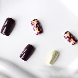 Short square press-on nails featuring purple glossy finish, maple leaf art and gold glitter
