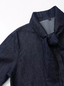 Détail du col d'une chemise en jean bleu foncé avec nœud élégant et étiquette taille M