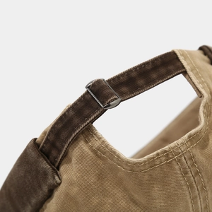 Detail of the metal adjustment buckle and washed cotton texture on a retro docker hat