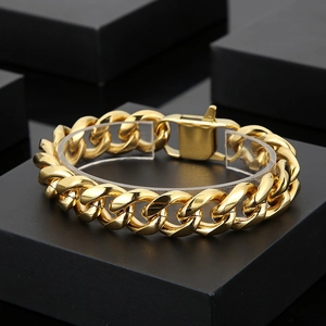 Close-up of a premium gold-plated Cuban link bracelet displayed on a sleek black stand