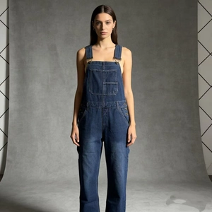 Detailed view of dark blue denim overalls featuring chest pockets and classic metal buckles