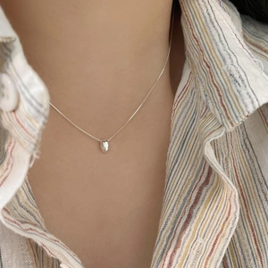 Close-up of minimalist 925 sterling silver bean pendant necklace worn on model